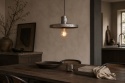 Metalowa lampa wisząca SKYE Zuiver nad drewnianym stołem w ciepłym wnętrzu modern loft z dekoracyjną żarówką filamentową