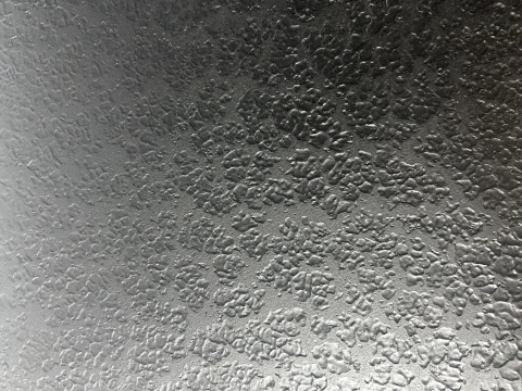 Detal metalicznej struktury wykończenia liquid metal na blacie stolika Winston