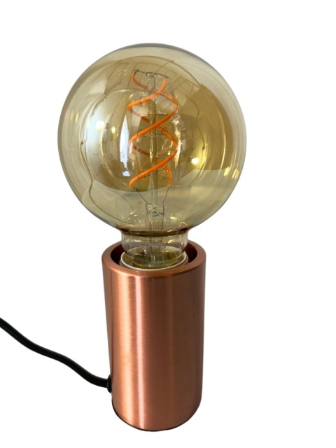 Żarówka Globe L zamontowana w miedzianej oprawie lampy stołowej.